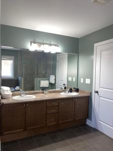 a bathroom with two sinks and a large mirror at 3300 SqFt - Modern and Comfort - 3 BDRM Getaway - Relax - Unwind - Explore - Near Toronto Pearson Airport & Toronto Downtown in Brampton