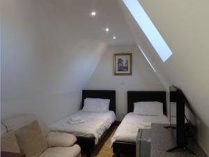 a attic room with two beds and a couch at Hay Lane Lodge in Shirley