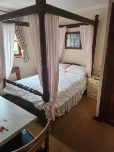 a bedroom with a four poster bed with curtains at Hay Lane Lodge in Shirley +4 photos