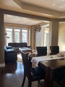 a living room with a table and a couch at 3300 SqFt - Modern and Comfort - 3 BDRM Getaway - Relax - Unwind - Explore - Near Toronto Pearson Airport & Toronto Downtown in Brampton +49 photos
