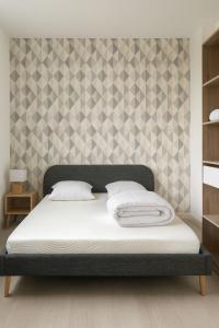 een bed in een slaapkamer met een muur met een stencil bij spacieux logement proche amnéville in Uckange