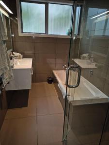 a bathroom with a sink and a tub and a window at Seaviews on Sullivans in Paihia
