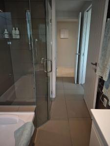 a bathroom with a glass shower and a sink at Seaviews on Sullivans in Paihia
