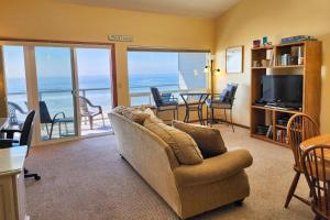 a living room with a couch and a table and chairs at Nye Beach Ocean Front Condo! Ocean Memories in Newport