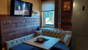 a room with a couch and a table and a tv at Apartments Artic in Jahorina