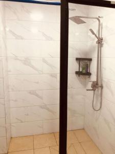 a shower with white marble tile in a bathroom at Samoa FINAU 685 Accomodations in Vaitele