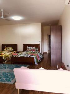 una habitación con dos camas y un sofá en Samoa FINAU 685 Accomodations, en Vaitele