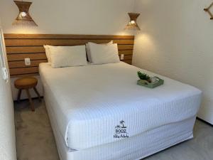 a bedroom with a large bed with a white bedspread at Milagres - VIllas Patacho in Pôrto de Pedras