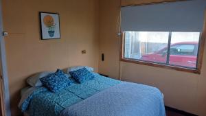 蓬塔阿雷纳斯Casa Celeste的卧室里有一张床，床铺是蓝色的，还有一扇窗户