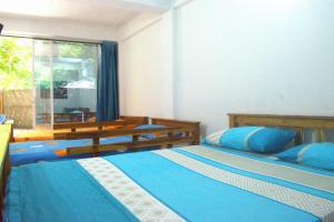 a bedroom with two beds with blue sheets and a window at MANGO BREEZE Casa de Playa en Tierrabomba in Tierra Bomba
