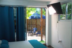 a bedroom with a bed and a sliding glass door at MANGO BREEZE Casa de Playa en Tierrabomba in Tierra Bomba