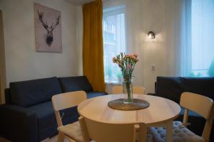 a living room with a table with a vase of flowers on it at Rynek Centrum Katowice in Katowice