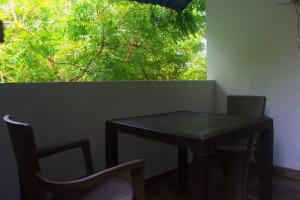 a black table and chairs in a room with a window at MANGO BREEZE Casa de Playa en Tierrabomba in Tierra Bomba