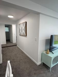 a living room with a tv and a table at Space, Style and Serenity in Lower Hutt