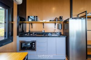 une cuisine avec une cuisinière et un réfrigérateur dans l'établissement Cabana c/ jacuzzi e vista para as montanhas VST031, à São Paulo dos Pinhais 23 autres photos
