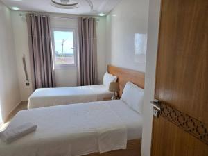 スコイラにあるInstant Saisons - Ferme d'hôtesのベッドが2つと窓があるホテルの部屋
