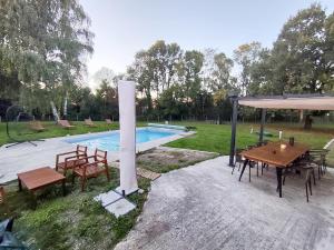 a pool with a table and chairs and a pavilion at Felicità - Longère with swimming pool and large garden in Poulaines +40 photos