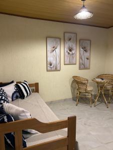 a bedroom with three pictures of flowers on the wall at Suite Tarituba 2 in Angra dos Reis