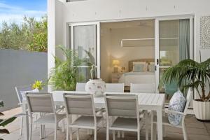 a white table and chairs on a patio with a bedroom at Ocean Breeze on Malibu in Kingscliff