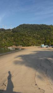 a shadow of a person taking a picture of the beach at Suite Tarituba 2 in Angra dos Reis