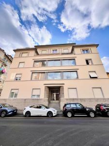 ベルガモにあるCharming Stay Bergamo City Centerの大きな建物の前に駐車した車両2台