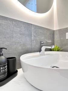 ベルガモにあるCharming Stay Bergamo City Centerの白い洗面台と鏡のあるバスルーム +27枚の写真