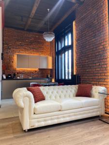 a white couch in a room with a brick wall at Old city apart in Ivano-Frankivsʼk