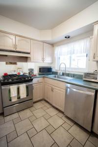 una cucina con lavello e fornello forno superiore di Charming Getaway Make Memories a Sterling Heights Altre 70 foto