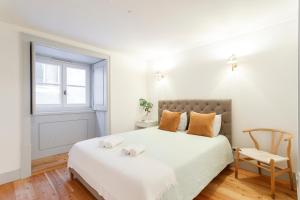 a white bedroom with a bed and a chair at Suite in Cozy Apartment in Chiado in Shared House in Lisbon +9 photos