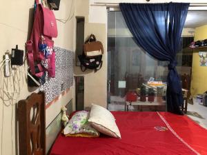 a bedroom with a bed with a red blanket and a window at COP 30 suíte com sala e cozinha familiar in Belém