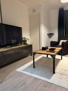 2 Bedroom Apartment - Close to Disney - Fully Equipped في كوبفراي: غرفة معيشة مع طاولة قهوة وتلفزيون بشاشة مسطحة