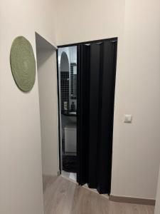 2 Bedroom Apartment - Close to Disney - Fully Equipped في كوبفراي: مدخل مع باب أسود ومرآة