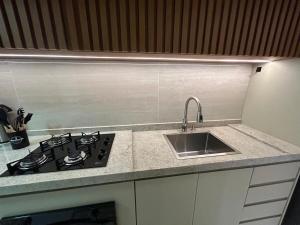 una cocina con estufa y fregadero en Cobertura pé na areia, 3 suítes e área externa, en Ilhéus 23 fotos más