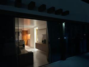 Habitación oscura con vistas a la sala de estar. en Cobertura pé na areia, 3 suítes e área externa, en Ilhéus