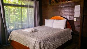 une chambre avec un lit avec un animal en peluche dessus dans l'établissement La Fortuna Waterfall Bungalows, à Fortuna