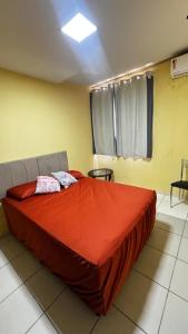 Santa InêsにあるApto por temporadaの赤い掛け布団が敷かれたベッドのある寝室