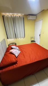 Santa InêsにあるApto por temporadaのベッドルーム1室(大型赤いベッド1台、枕2つ付)