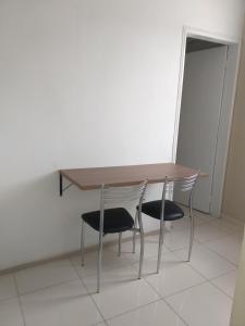 Santa InêsにあるApto por temporadaの木製テーブルと椅子2脚