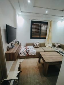 a living room with a couch and a tv at Imsouane ocean view in Imsouane