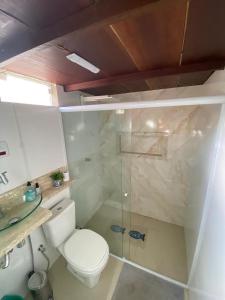une salle de bain avec toilettes et douche en verre dans l'établissement Casa Amarela em Cacha Pregos, à Vera Cruz de Itaparica