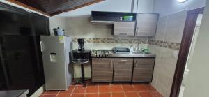 a small kitchen with a sink and a refrigerator at Casa Campestre Villa Isabel tu Escape Perfecto in Cali