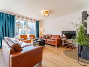 a living room with a couch and a tv at JooP in Niedernsill