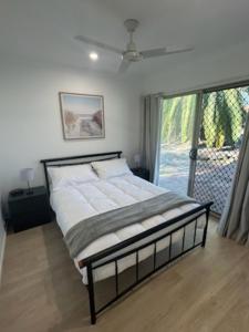 a bedroom with a large bed with a window at Birkdale Granny Flat in Birkdale