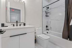a white bathroom with a sink and a toilet and a tub at Lux 2Bedroom apartment in Washington DC Dupont in Washington