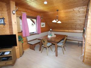 comedor con mesa y sofá en una cabaña en Mooshausl, en Gnesau Sonnleiten
