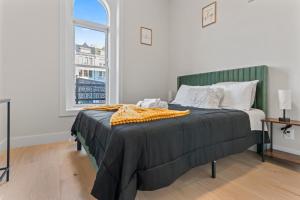 a bedroom with a bed with a green headboard and a window at Lux 2Bedroom apartment in Washington DC Dupont in Washington