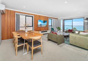 una sala de estar con una mesa y un sofá en Morning Glow - Wake up to breathtaking views and golden sunrises at this serene coastal retreat., en Bombo