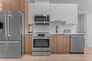 a kitchen with stainless steel appliances and wooden cabinets at Lux 2Bedroom apartment in Washington DC Dupont in Washington +22 photos