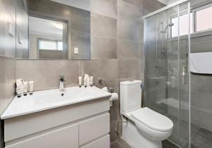 Un baño con inodoro, lavabo y ducha. en Morning Glow - Wake up to breathtaking views and golden sunrises at this serene coastal retreat., en Bombo 11 fotos más