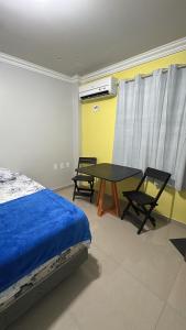马瑙斯Quarto próximo ao centro 2的一间卧室，里面有一张床、一张桌子和几把椅子。
